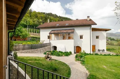 a white house with a fence and a yard at Steidacherhof in Longomoso