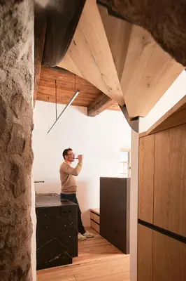 a man taking a picture in a room with wood ceilings at Steidacherhof in Longomoso