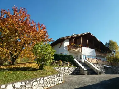 a large white house with a stone wall at Garni Sonnegg in Petersberg