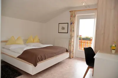 a bedroom with a bed with yellow pillows and a window at Garni Sonnegg in Petersberg