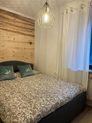 a bedroom with a bed and a chandelier at Apartment Oberprisch in San Leonardo in Passiria