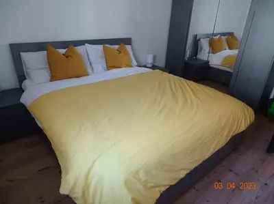 a bedroom with a large bed with yellow sheets and pillows at Panoramaterrace, Wein & relax in Appiano Sulla Strada Del Vino