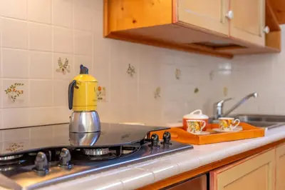 a tea kettle sitting on top of a stove in a kitchen at mansarda Lungolago in Alleghe