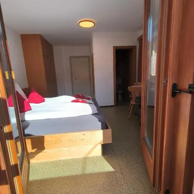 a bedroom with a bed with red pillows at B&B Garni Lantschner in Kastelruth
