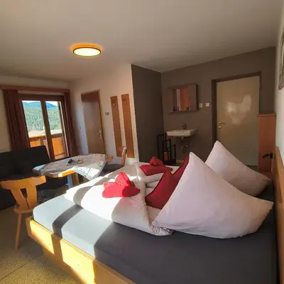 a bedroom with a large bed with white pillows at B&B Garni Lantschner in Kastelruth