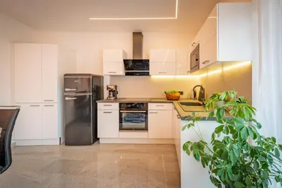a kitchen with white cabinets and a stainless steel refrigerator at Ferienhof Hanna in Termeno