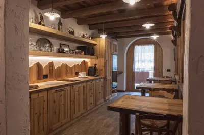 a kitchen with wooden cabinets and a wooden table at ALLE ANTICHE MINIERE - CASA VACANZE in Zenich