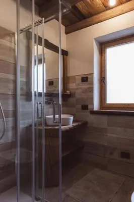 a bathroom with a glass shower and a sink at ALLE ANTICHE MINIERE - CASA VACANZE in Zenich