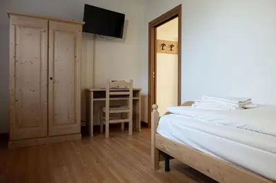 a bedroom with a bed and a desk and a mirror at ALLE ANTICHE MINIERE - CASA VACANZE in Zenich