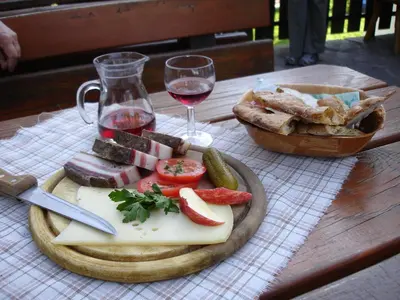 a plate of cheese and bread and a glass of wine at Webergütl in Auna di Sopra