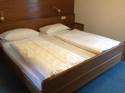a bed with two white pillows and a wooden headboard at Garni Pineta in San Martino in Badia