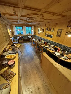 a large room with tables and chairs in a restaurant at Garni Pineta in San Martino in Badia