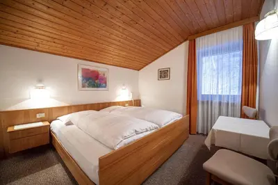 a bedroom with a large bed and a window at Alara Rooms in Ortisei