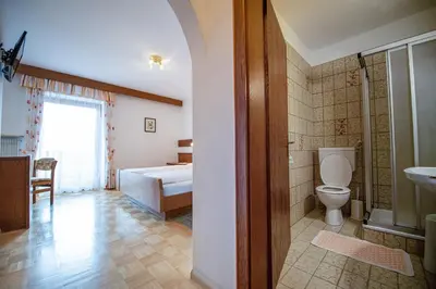 a bathroom with a bed and a toilet and a sink at Zilli Rooms in Laion