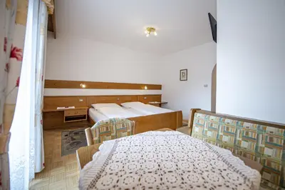 a bedroom with two beds and a table and a bed at Zilli Rooms in Laion