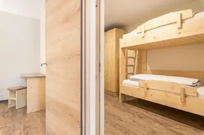 a bedroom with a bunk bed and a closet at Villa Lara Föhre in Kastelruth