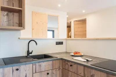 a kitchen with a sink and wooden cabinets at Villa Lara Föhre in Kastelruth