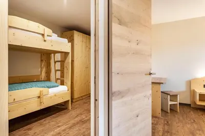 a room with two bunk beds and a closet at Villa Lara Föhre in Kastelruth