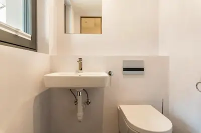 a white bathroom with a sink and a toilet at Villa Lara Föhre in Kastelruth