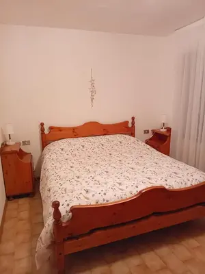a bedroom with a large bed with a wooden frame at Casa Sartorin in Canale San Bovo