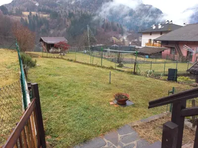 a yard with a fence and a field of grass at Casa Sartorin in Canale San Bovo