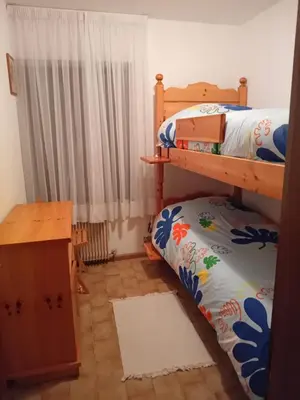 a bedroom with two bunk beds and a table at Casa Sartorin in Canale San Bovo