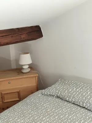 a bedroom with a bed and a lamp on a dresser at Casa Relax in Canale San Bovo