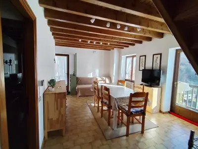 a kitchen and living room with a table and chairs at Casa Relax in Canale San Bovo