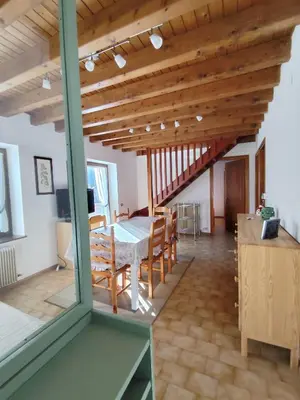 a room with a table and chairs and a wooden ceiling at Casa Relax in Canale San Bovo