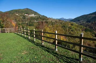 a fence on the side of a hill at Hostel L'Ost - Ostello di Grumes in Grumes