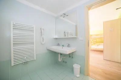 a bathroom with a sink and a mirror at Hostel L'Ost - Ostello di Grumes in Grumes
