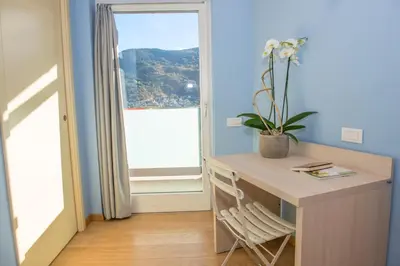 a home office with a desk and a window at Hostel L'Ost - Ostello di Grumes in Grumes