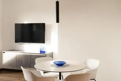 a white dining room with a white table and chairs at Moerlhof in Caldaro