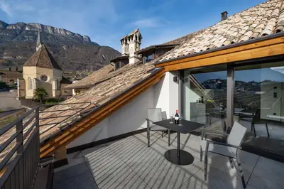a balcony with a table and chairs on a house at Moerlhof in Caldaro