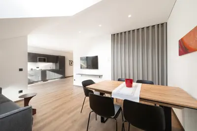 a dining room and living room with a wooden table and chairs at Moerlhof in Caldaro