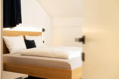 a bedroom with a bed with white sheets and pillows at Moerlhof in Caldaro