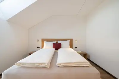 a bedroom with a large white bed with two pillows at Moerlhof in Caldaro