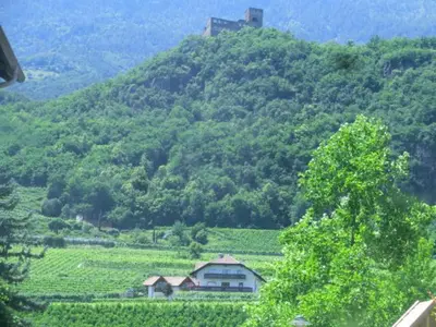 a house on top of a hill with a mountain at Weinhof Kager in Missiano