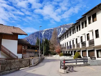 an empty street in a town with mountains in the background at Casa Righini in Moena