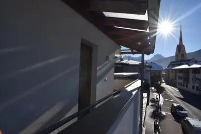 a balcony with a view of a street and a church at T&B MOUNTAIN VIEW in Monguelfo