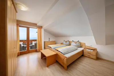 a bedroom with a bed and a large window at Pichlerhof in Avelengo