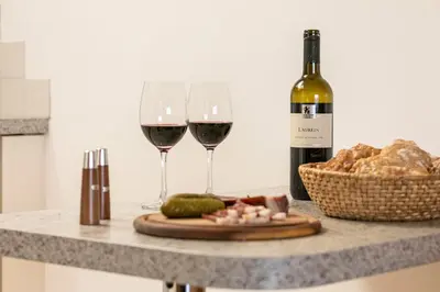 a table with two glasses of wine and a basket of bread at Pichlerhof in Avelengo
