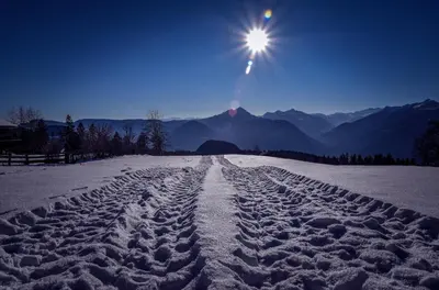 a snow covered road with the sun in the sky at Pichlerhof in Avelengo