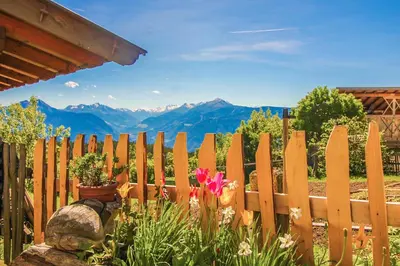 a wooden fence with a flower in a garden at Pichlerhof in Avelengo