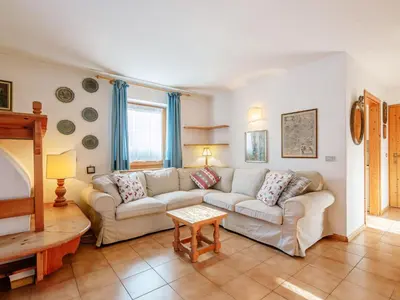 a dining room with a table and a television at Apartment Mason Scarzin by Interhome in Alba di Canazei