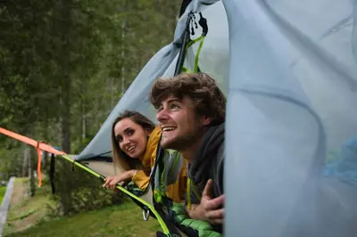 a man and a woman standing in front of a tent at Camping Marmolada Malga Ciapela - Glamping Experience in Malga Ciapela