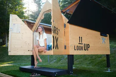 a woman is sitting in a play house at Camping Marmolada Malga Ciapela - Glamping Experience in Malga Ciapela