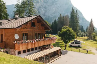 a building with flowers on the balcony of it at Camping Marmolada Malga Ciapela - Glamping Experience in Malga Ciapela