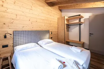 two beds in a room with wooden walls at - Piz Boe - Canazei center app. in Canazei