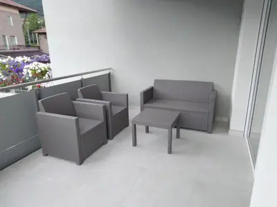 a balcony with a chair and a table at Loft 69 - Green Relax in Cles